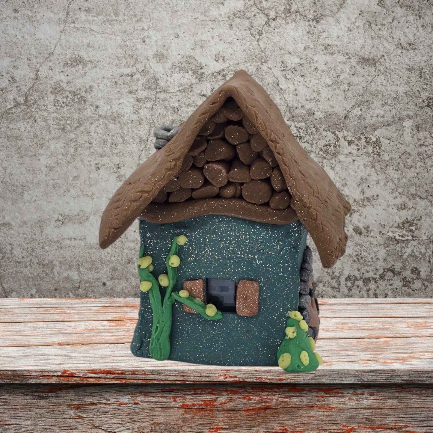 A small house featuring a sloped roof and a front door, set against a simple background.