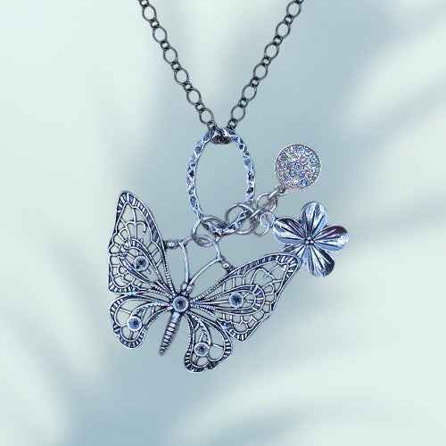 A LONG CHAIN NECKLACE WITH A BUTTERFLY CHARM