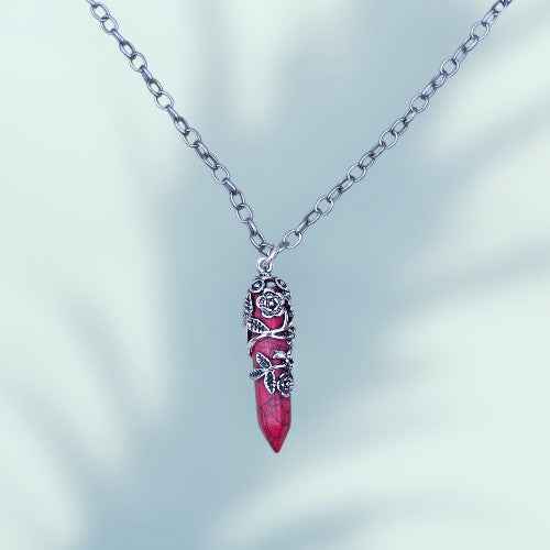 A LONG CHAIN NECKLACE WITH A RED PENDANT