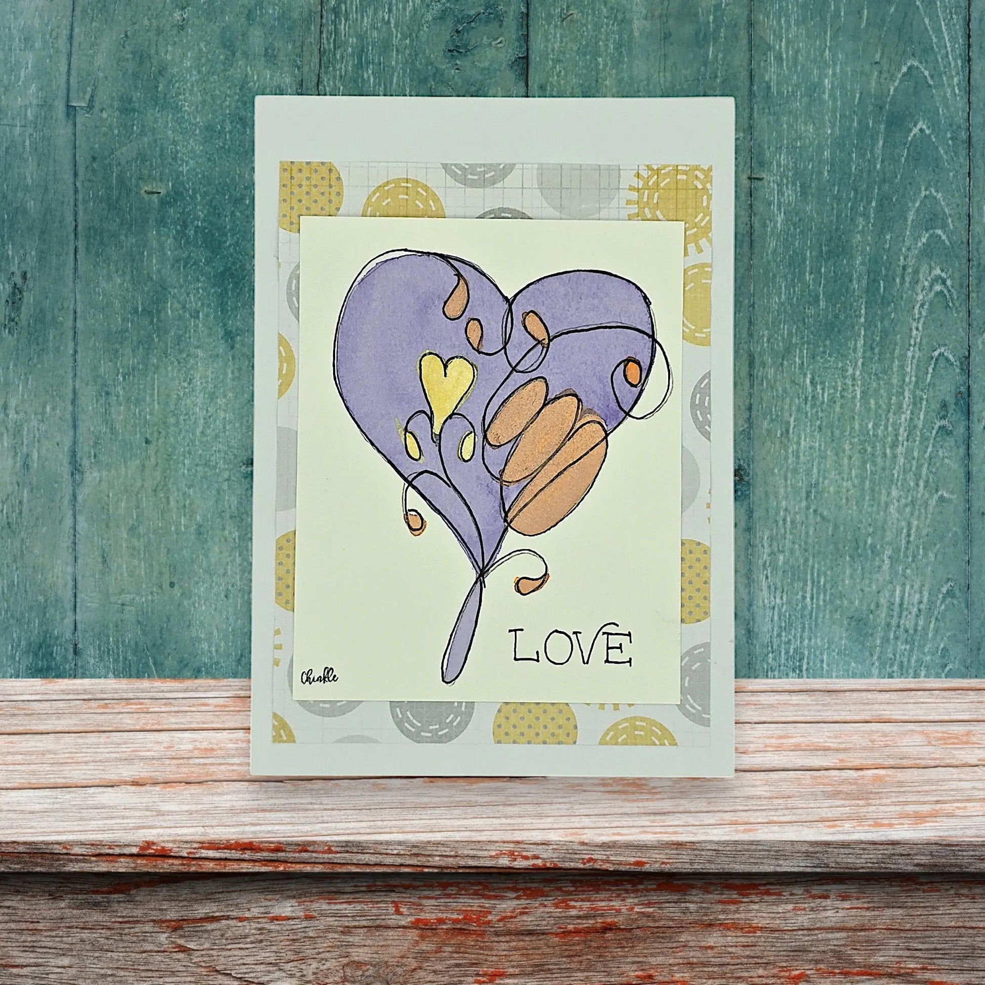 A LOVE CARD WITH LARGE PURPLE HEART AND WORDS LOVE WRITTEN ON FRONT
