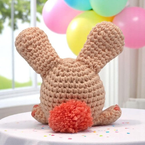 peach bunny head with big ears facing his back to you showing you his tail