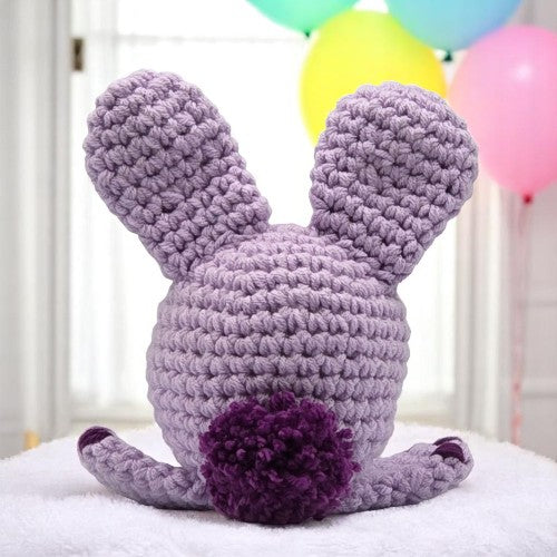 lavender bunny head with big ears facing his back to you showing you his tail