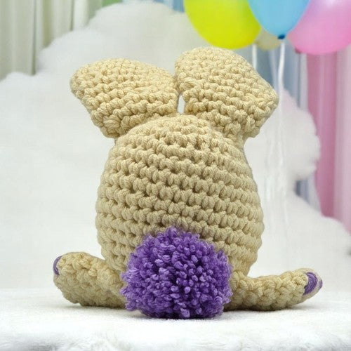 yellow bunny head with big ears facing his back to you showing you his tail