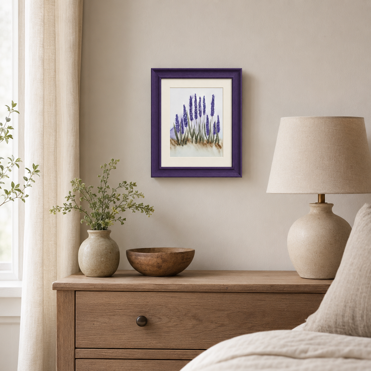 A framed floral art print featuring purple lavender stalks, styled on a beige wall above a wooden nightstand with a lamp, vase, and bowl in a bedroom setting.