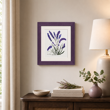 Framed botanical wall art featuring purple lavender flowers with green stems, displayed in a deep purple frame on a beige wall above a wooden console table with a lamp, books, and a bowl.