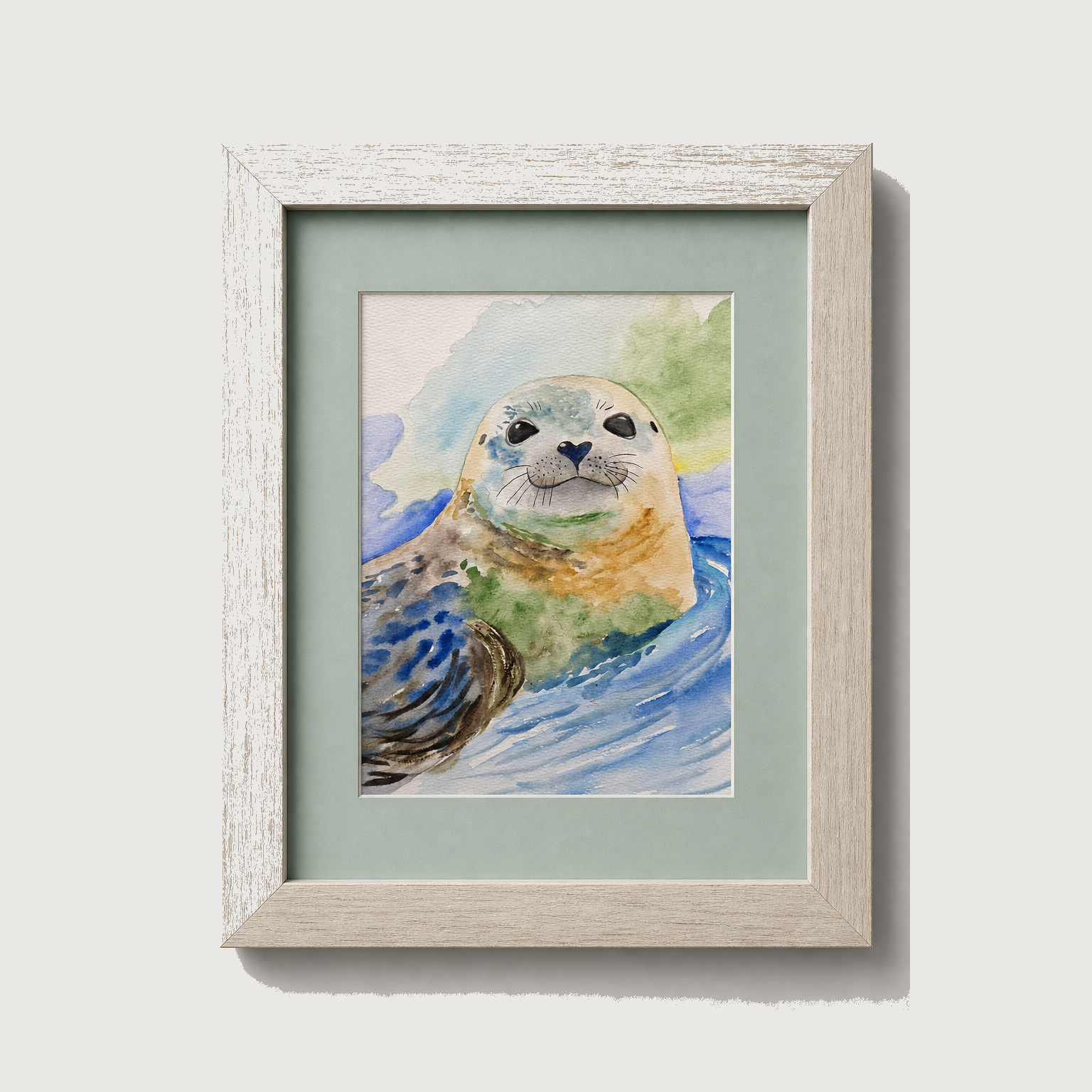 Framed watercolor art print of a seal in blue water, set in a light wood frame with a pale green mat, shown against a neutral light gray background.