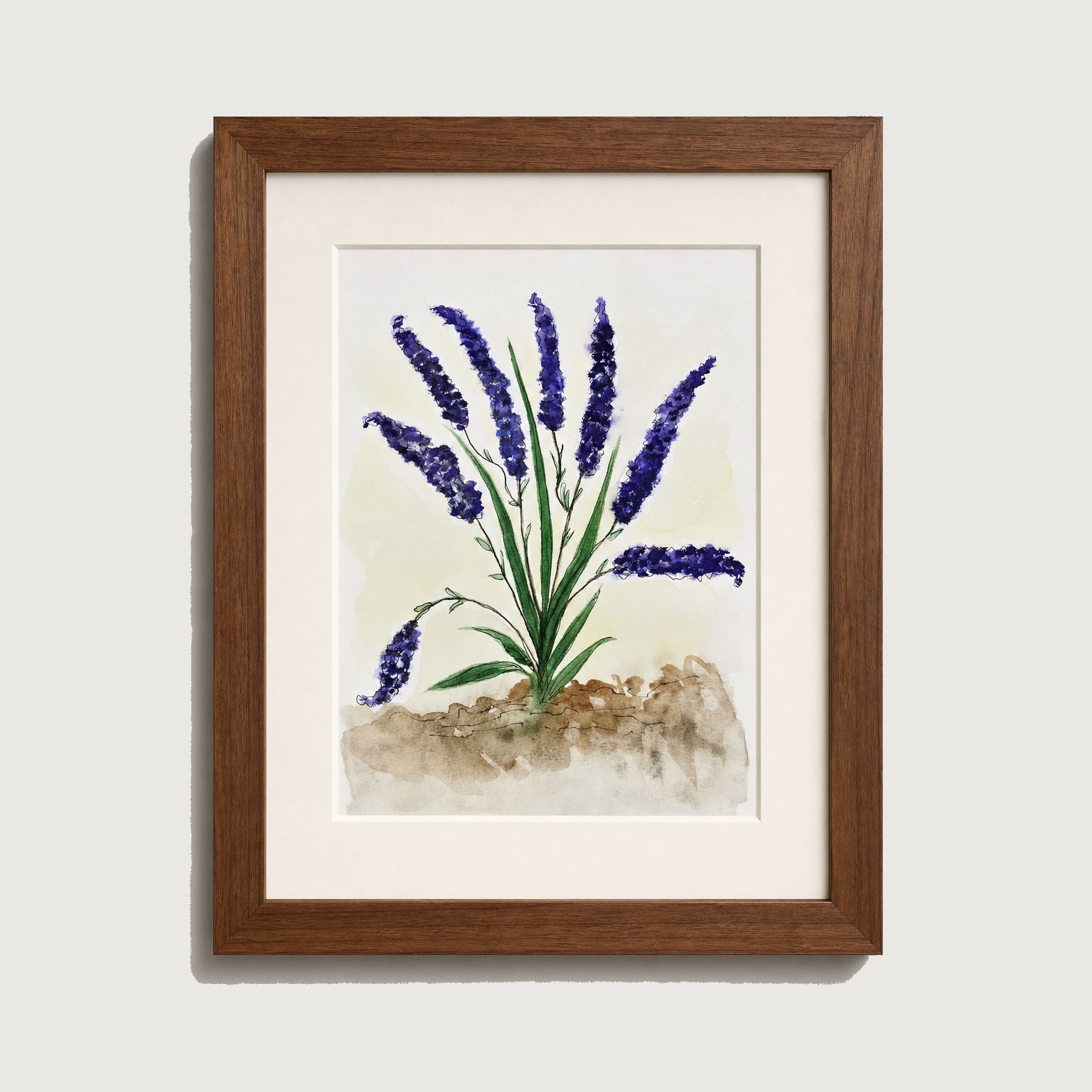 Framed watercolor art print of lavender flowers with purple blooms, green stems, and a textured beige ground, set in a white mat and a medium brown wooden frame against a light gray wall.