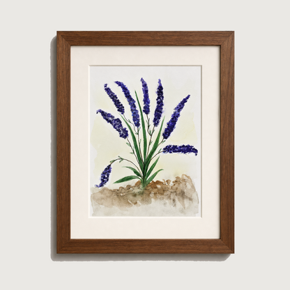 Framed watercolor art print of lavender flowers with purple blooms, green stems, and a textured beige ground, set in a white mat and a medium brown wooden frame against a light gray wall.