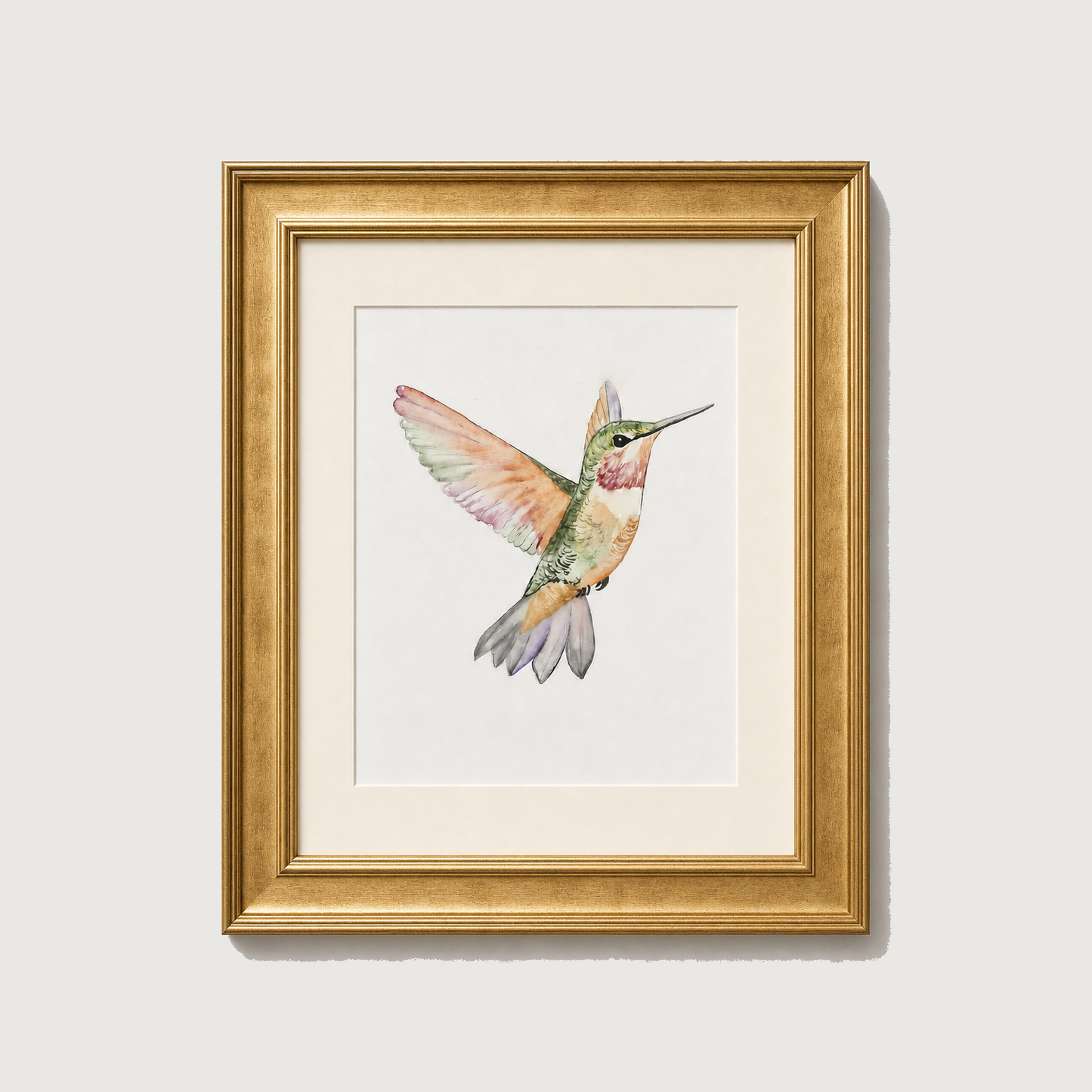 Framed watercolor art print of a hummingbird in flight, featuring a gold frame and white mat board against a light gray background.