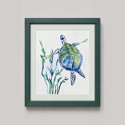 Framed watercolor art print of a sea turtle swimming among blue-green seaweed, set in a dark green frame against a light gray wall.