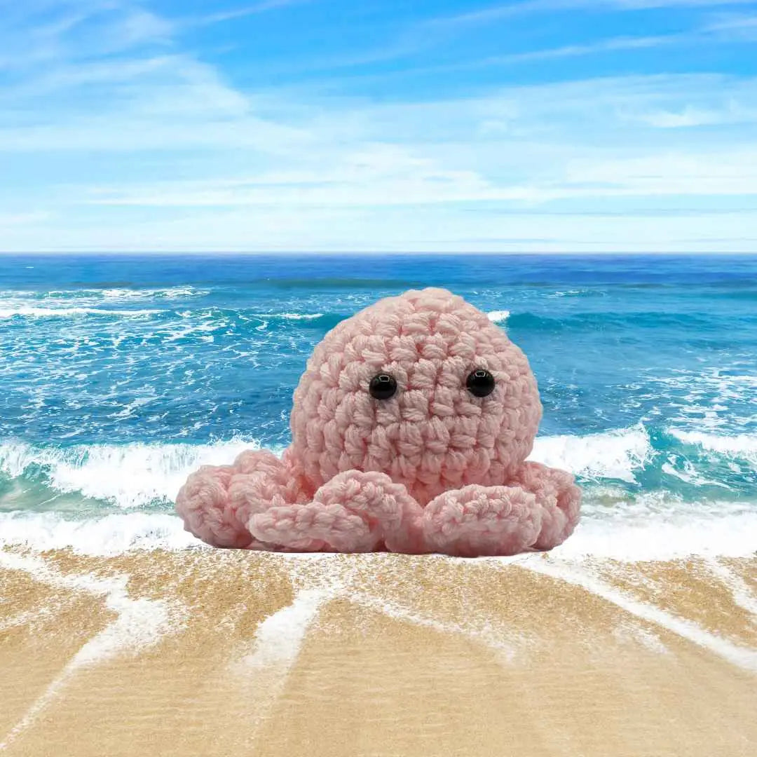 handmade crochet small baby octuput sitting in the ocean color is light pink
