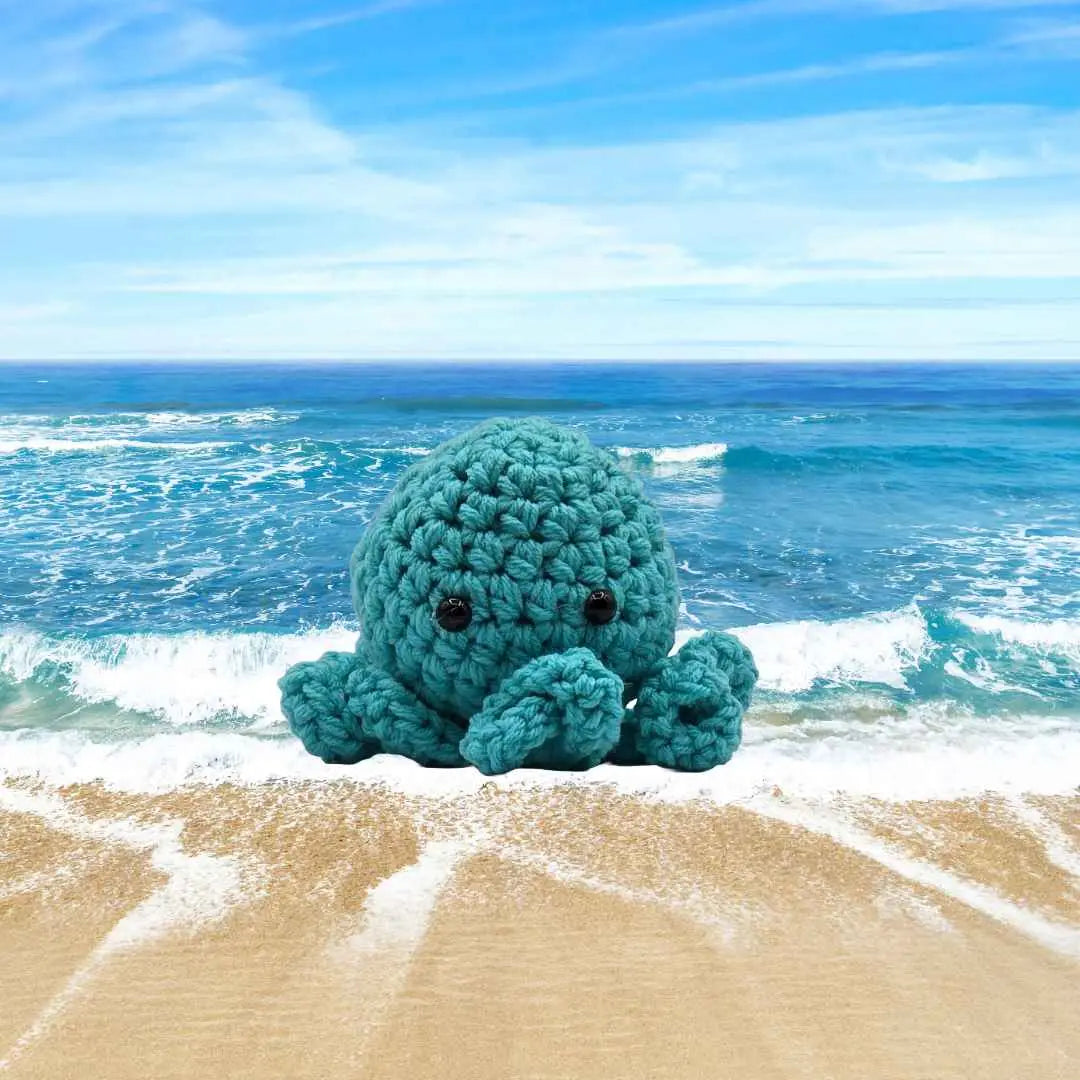 handmade crochet small baby octuput sitting in the ocean color is tourquoise