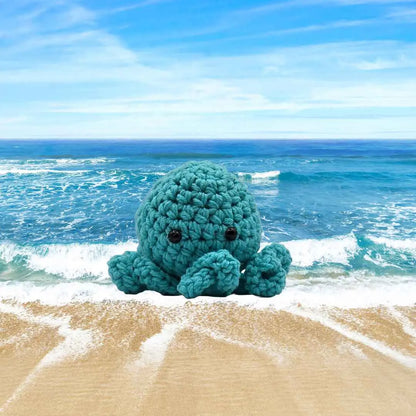 handmade crochet small baby octuput sitting in the ocean color is tourquoise