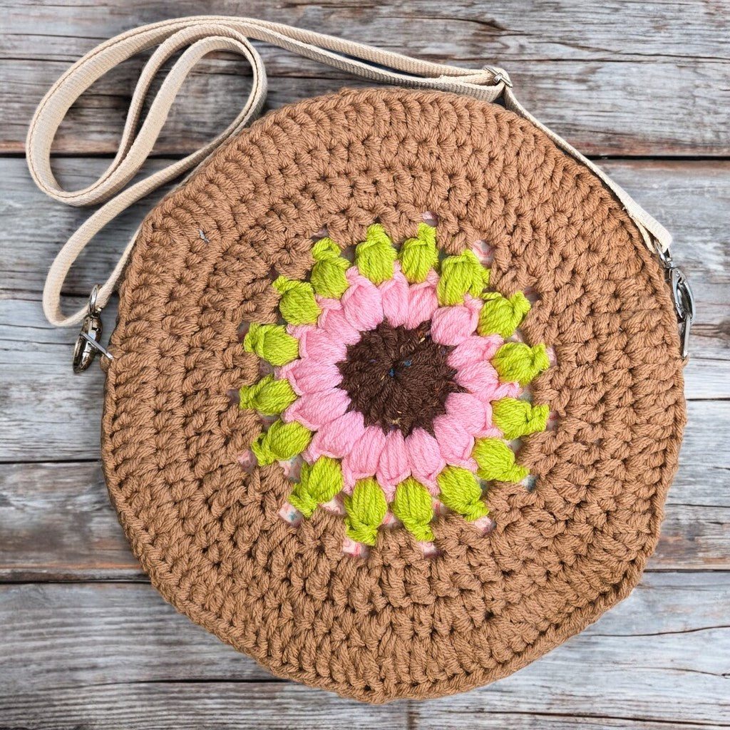 Round boho crochet bag with a floral design on a white background