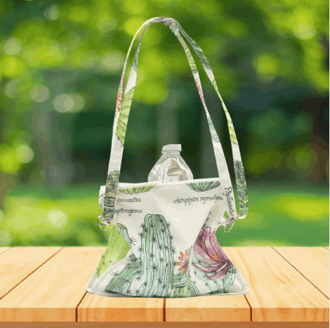 Handmade crossbody purse with cactus print, featuring two zippered pockets and one inner slip pocket.