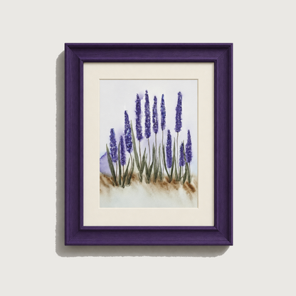 Framed watercolor art print of lavender flowers with a deep purple frame and white mat, shown against a light gray wall.