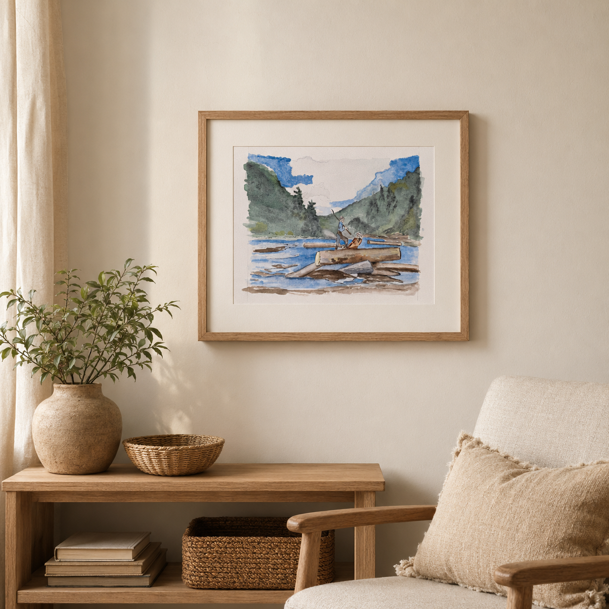 A framed art print depicting a scenic landscape with mountains, water, and a canoe, styled on a beige wall above a wooden console table with a potted plant and a chair.