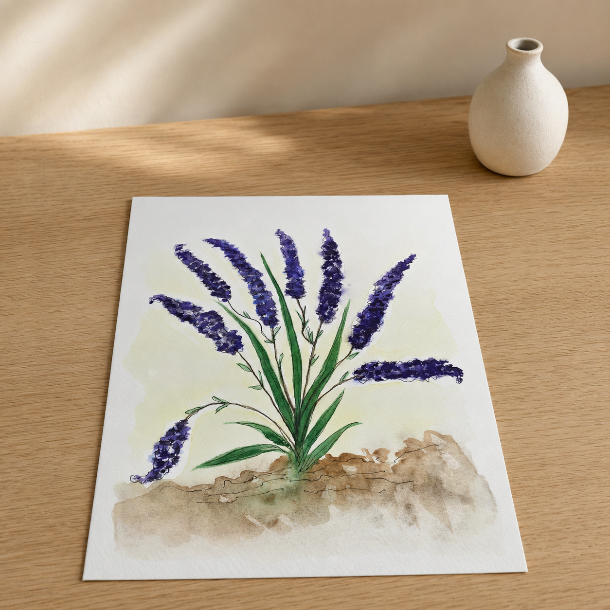 A square art print featuring a watercolor painting of purple lavender flowers with green stems and leaves, displayed on a light wooden table next to a small white ceramic vase.