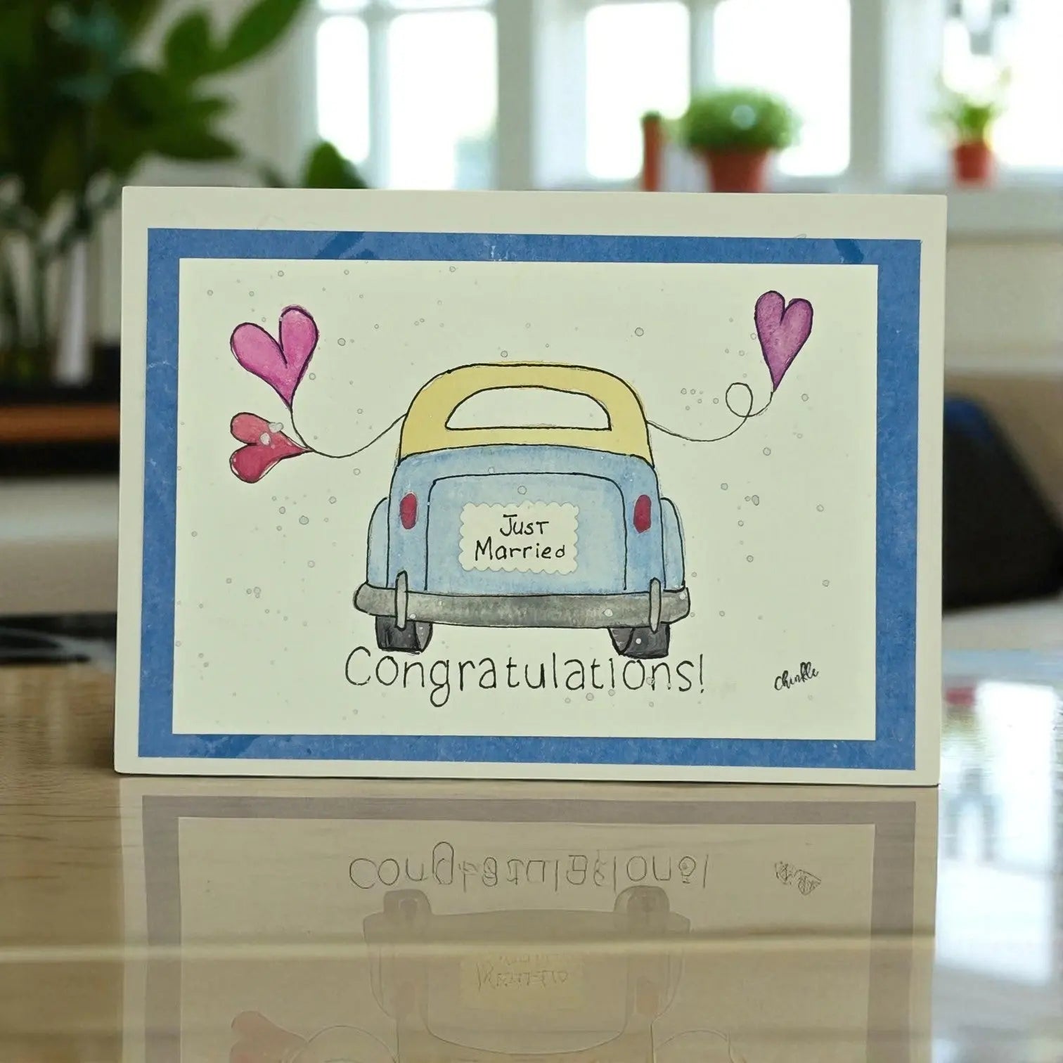  A wedding card displaying a car adorned with two hearts, representing romance and the journey of marriage.