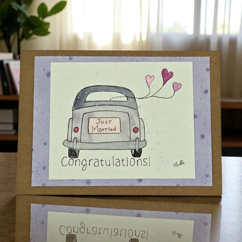  A wedding card featuring a decorated car with colorful balloons attached.