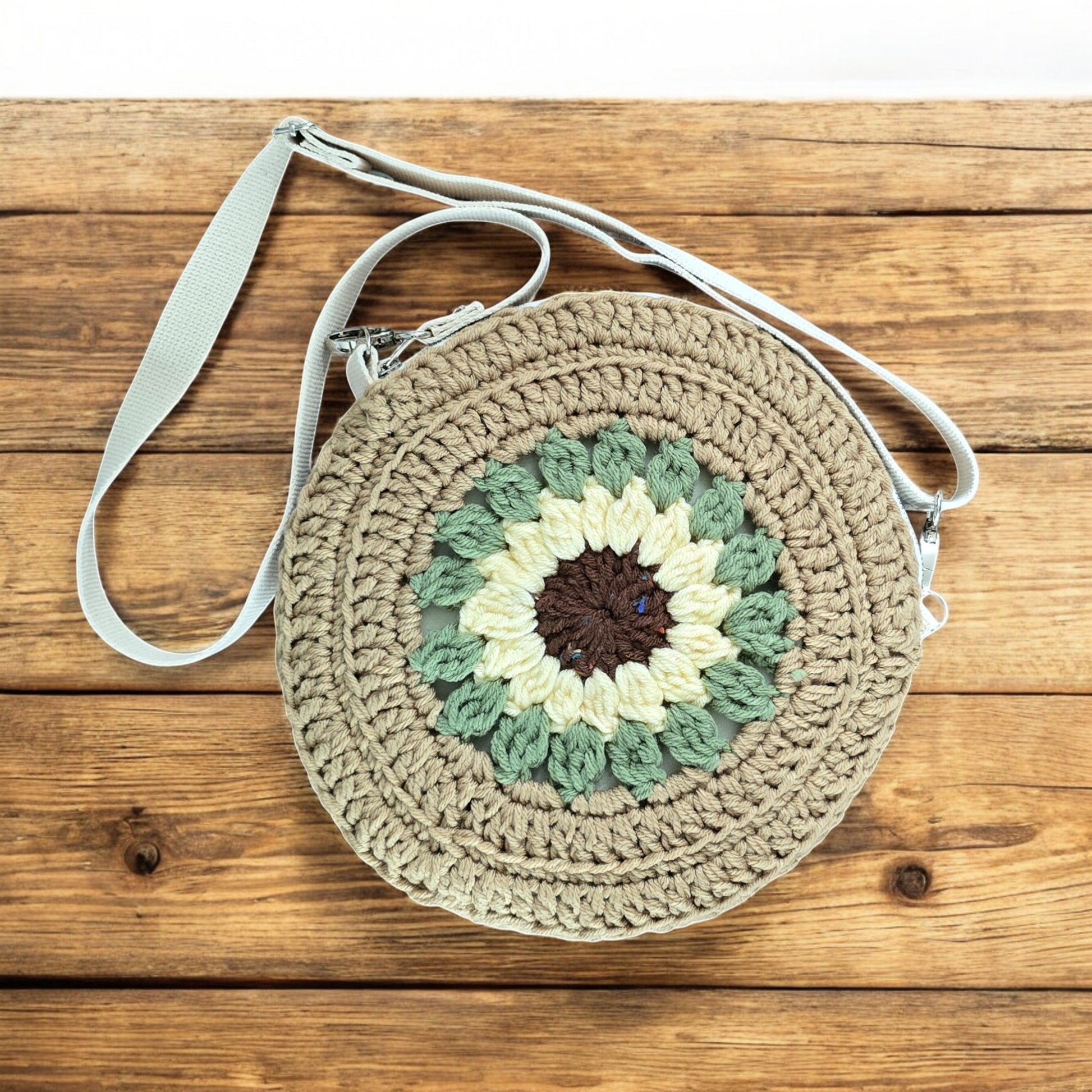 Round boho crochet bag with floral pattern on a wooden surface