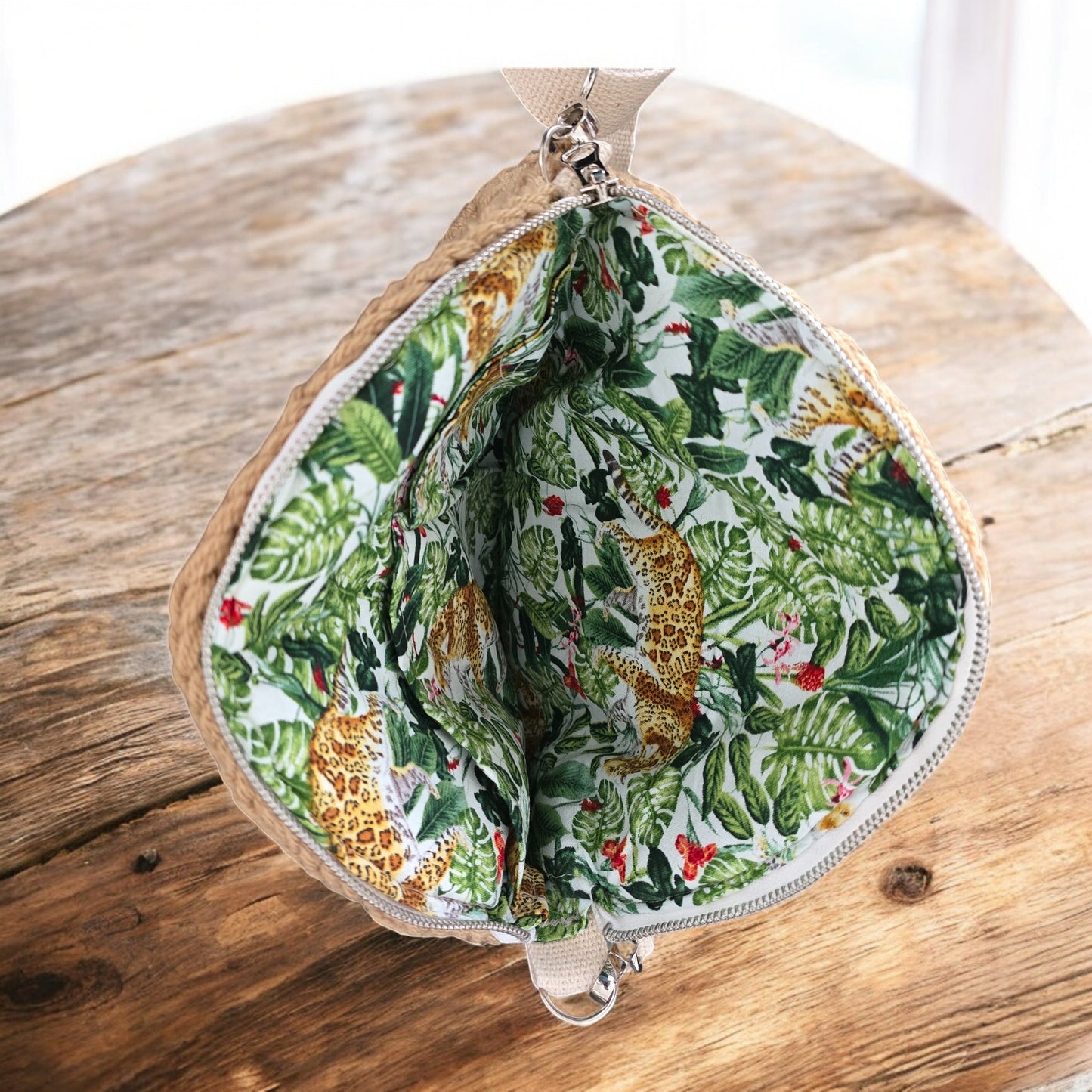 Jungle-themed lining with leopards and leaves on a wooden background as part of a boho crochet bag