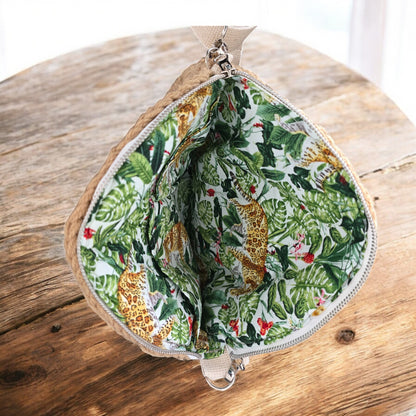 Jungle-themed lining with leopards and leaves on a wooden background as part of a boho crochet bag